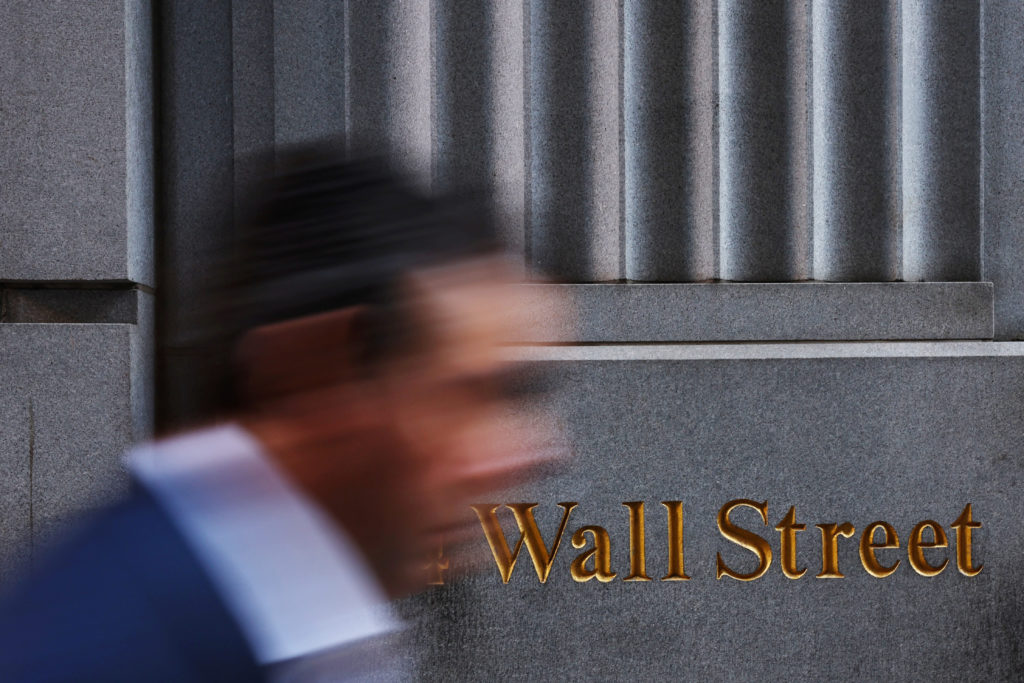 A man walks past a Wall Street marking outside the New York Stock Exchange (NYSE) building on Tuesday following Monday’s broad sell off in New York City, U.S., March 11, 2025. REUTERS/Shannon Stapleton